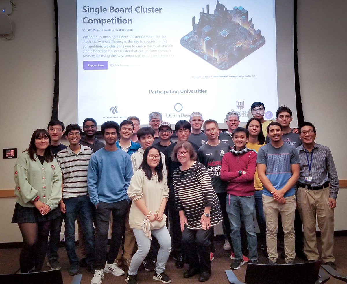 Group of contestants standing in front of a presentation screen