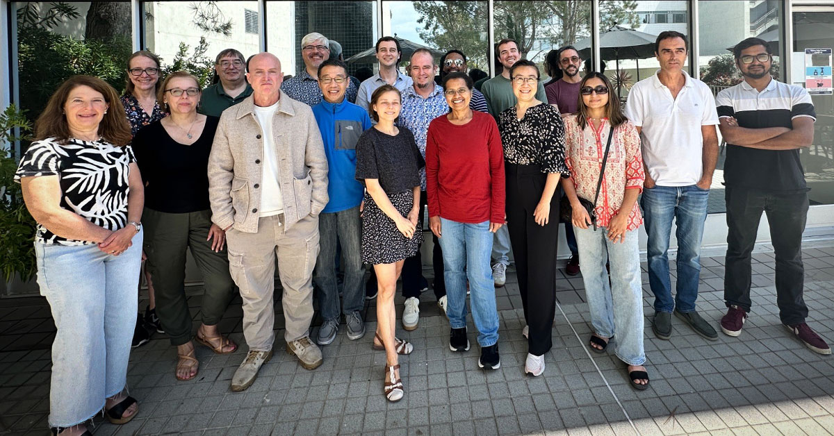 Group of people in front of SDSC's mirrored windows.